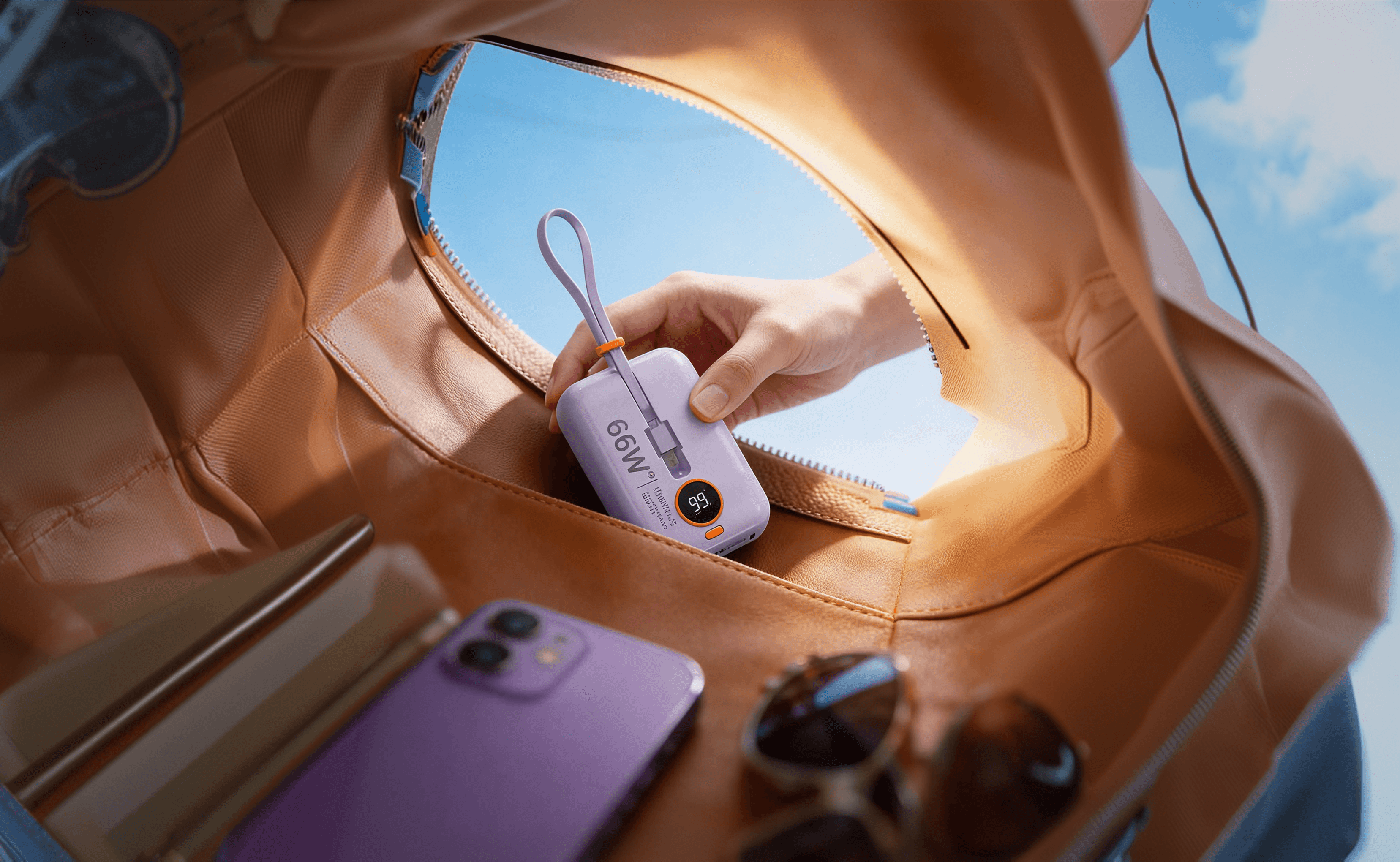 A branded bottle inside a warm tan bag with a phone nearby.